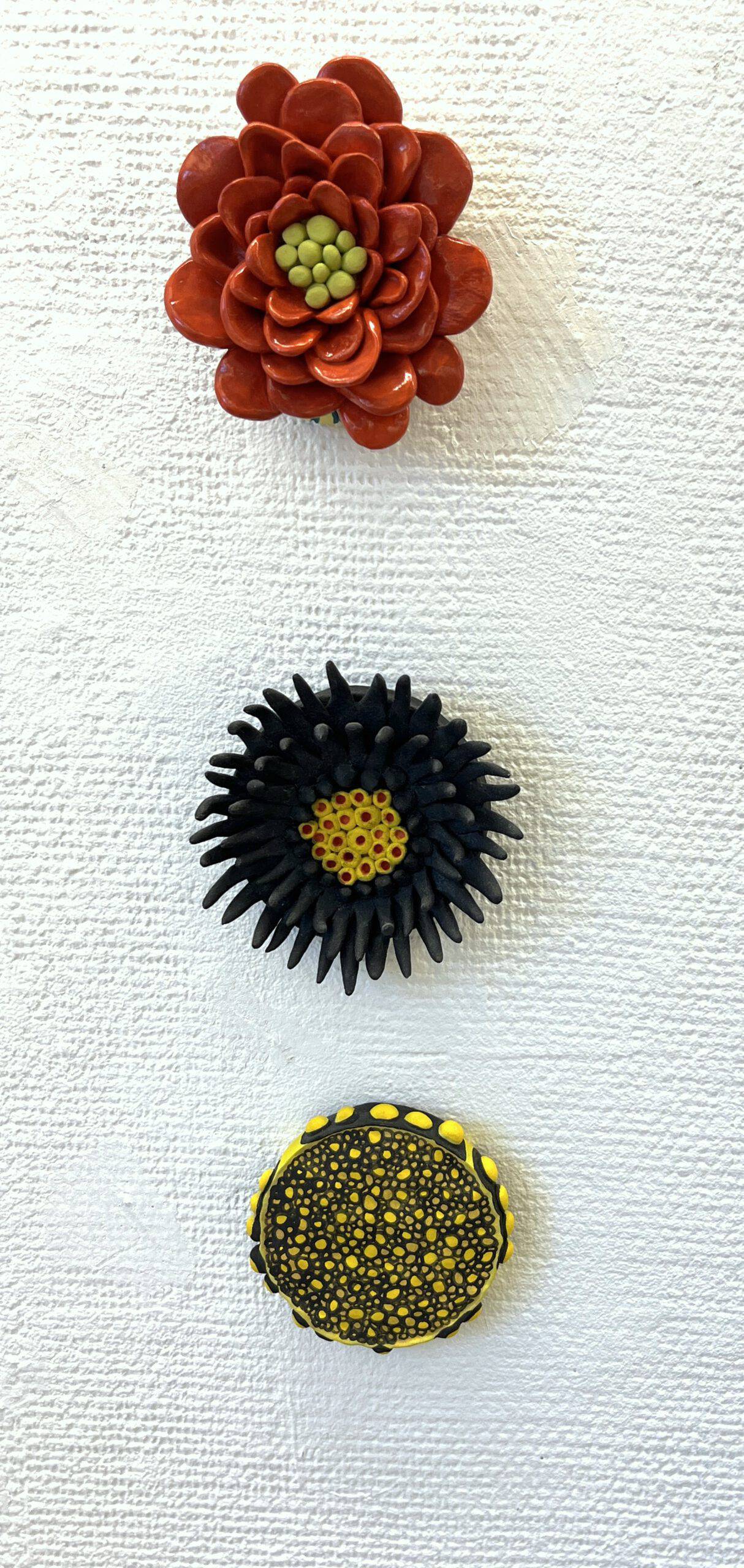 Installationen Blomster med Röd blomma, Svart blomma och Gul blomma. Del av separatutställningen Scenerier på Lysekils konsthall, 2024.